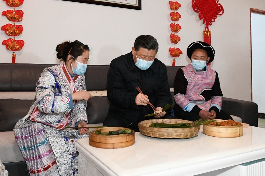 2021年2月3日下午，習(xí)近平在貴州畢節(jié)市黔西縣新仁苗族鄉(xiāng)化屋村苗族村民趙玉學(xué)家，同一家人邊聊家常邊制作當(dāng)?shù)貍鹘y(tǒng)節(jié)日食品黃粑。新華社記者 李學(xué)仁 攝